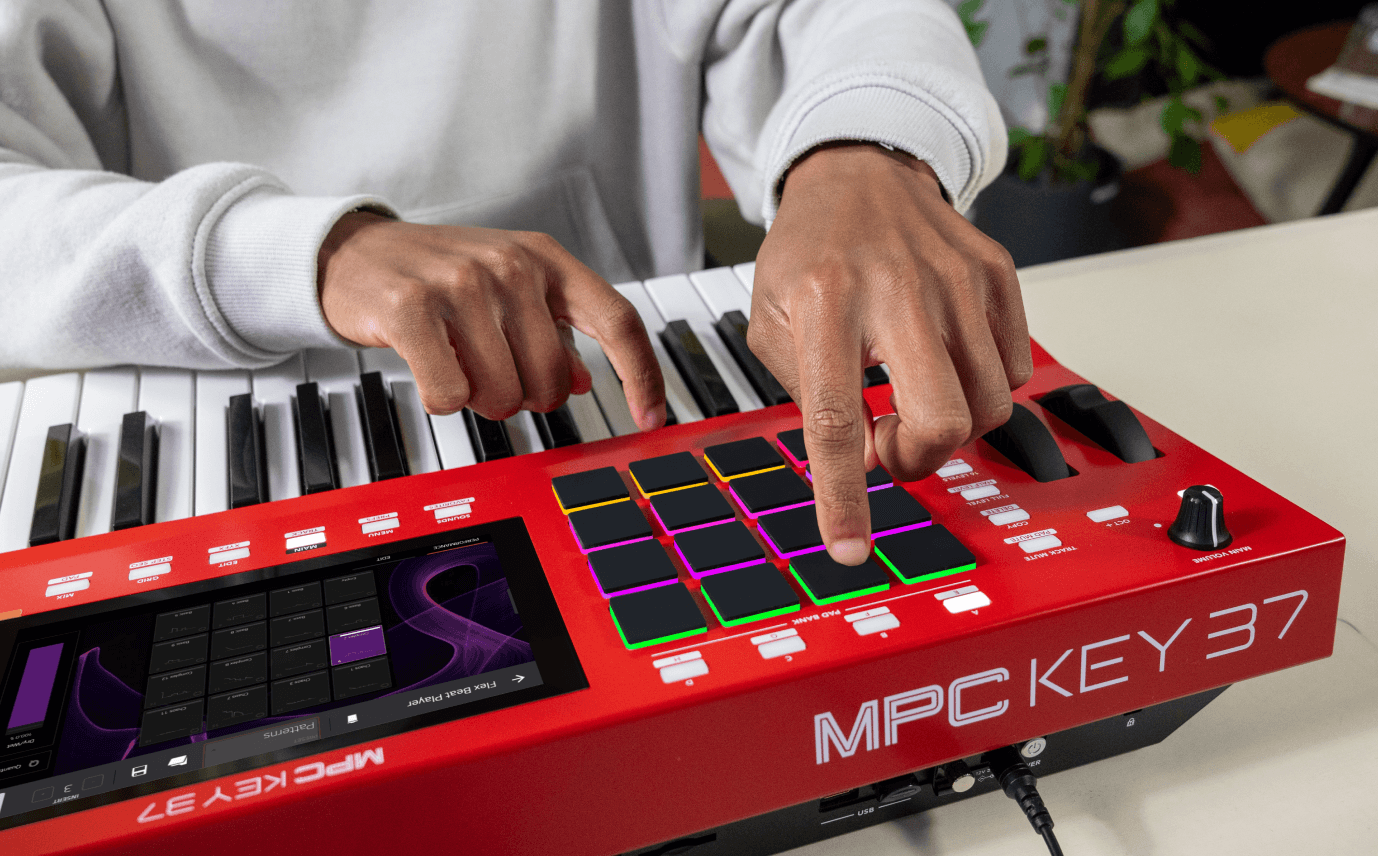 Medium-wide shot, hands on MPC Key 37 RGB pads